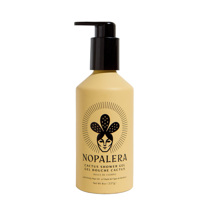 The 8oz yellow bottle of NOPALERAs Cactus Shower Gel features a black pump and a label with a stylized cactus person and the text Nopalera Cactus Shower Gel Gel Douche Cactus Dulce de Cuerpo. Infused with cactus flower extracts, it provides a refreshing cleanse.