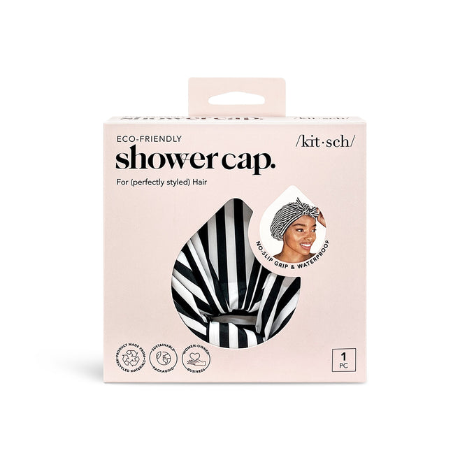 Kitschs Recycled Polyester Luxe Shower Cap features a chic turban design in black and white stripes, emphasizing its non-slip and waterproof qualities. The eco-friendly packaging complements the stylish accessory, showcased in an image of someone wearing it.