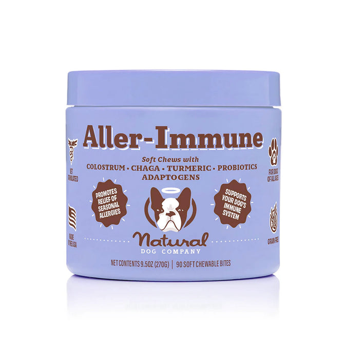 Natural Dog Companys Aller-Immune Supplement soft chews provide natural allergy relief and immune support for dogs with colostrum, chaga, turmeric, probiotics, and adaptogens. The purple jar with a dog illustration offers 90 bites and highlights seasonal allergy benefits.
