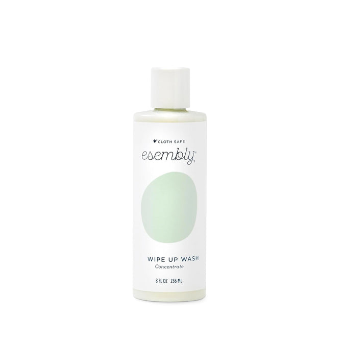 The Esembly Baby foamer bottle in white with a green label and white cap features the brand name and product description Wipe-Up Wash Refill. Its an organic foaming wipes cleanser clearly labeled as 8 fl oz or 236 mL.