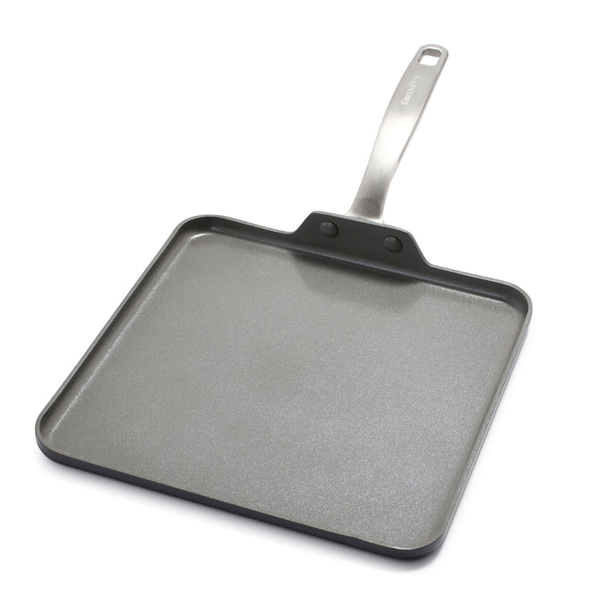 The Chatham Ceramic Nonstick Griddle Pan by GreenPan is an 11 square pan featuring a gray ceramic nonstick coating and a metallic handle with a hanging hole. Its low edges make it ideal for pancakes or grilled sandwiches, and its PFAS-free.