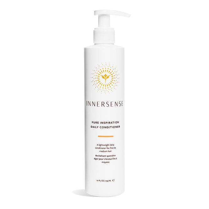 A white bottle of Innersense Organic Beauty Pure Inspiration Daily Conditioner with a pump, showing a yellow abstract flower design. This lightweight, moisturizing, detangling conditioner holds 10 fl oz (295 mL) as stated on the label.