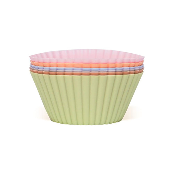 A stack of Net Zero Co. Silicone Baking Cups, made from BPA-free silicone with fluted sides and vibrant shades of green, pink, and blue, arranged in a nested pattern.