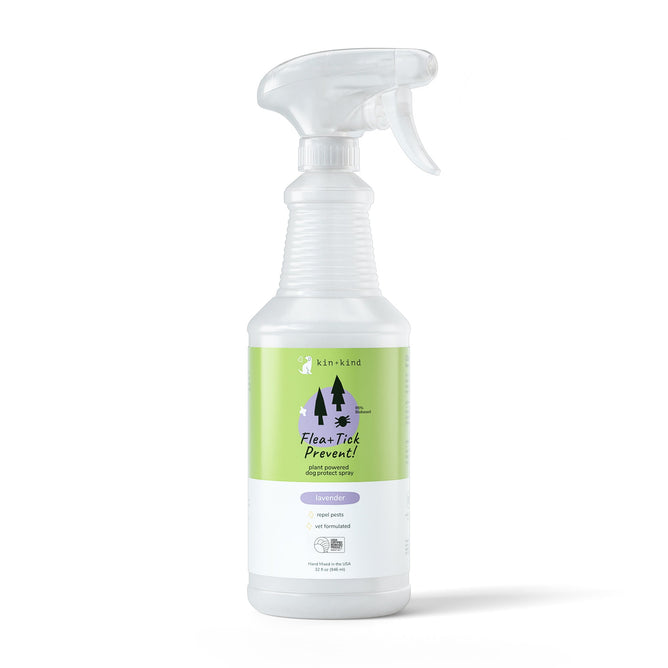 The kin+kind Flea+Tick Spray, vet formulated and USDA organic, comes in a clear spray bottle with a white nozzle. Its green label highlights a lavender scent and features tree and paw print graphics, designed for pets.