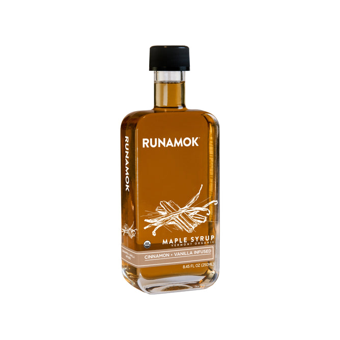 An 8.45 fl oz (250 ml) bottle of Runamok Cinnamon + Vanilla Infused Maple Syrup, with a black cap and a label showing cinnamon sticks and vanilla, offers rich, aromatic flavor.