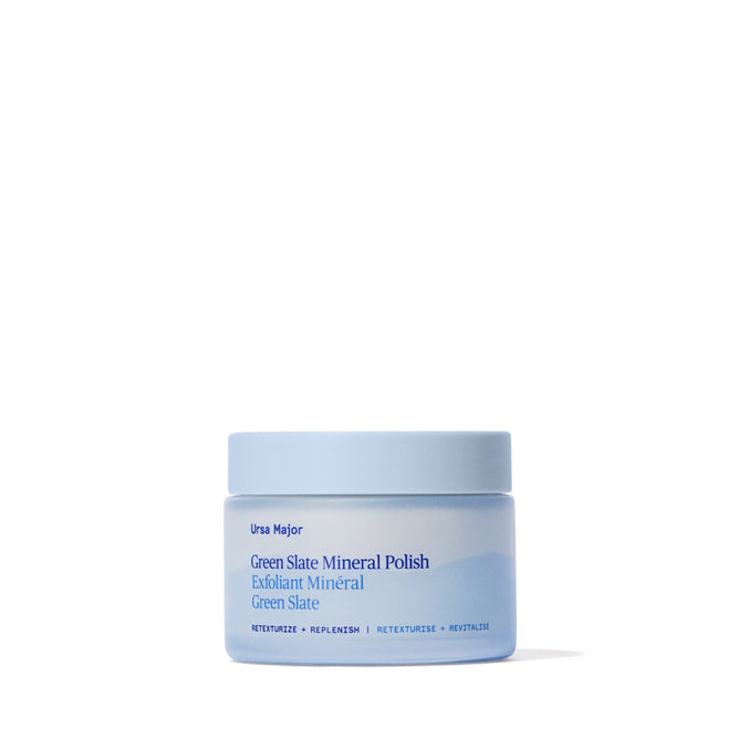A light blue jar of Ursa Majors Green Slate Mineral Polish, featuring blue text and a minimalist design, rests on a white background. This face polish is rich in minerals and uses natural exfoliants.