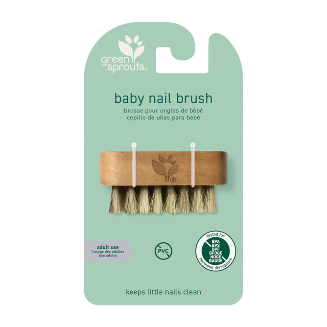 Green Sprouts Baby Nail Brush has light brown bristles and a wooden handle, made from all-natural materials. Its presented on a green card, emphasizing its PVC-free, BPA-free composition and renewable resources. The packaging includes English, French, and Spanish text.