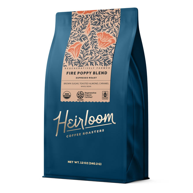 A blue bag of Heirloom Coffee Roasters Fire Poppy Espresso ROC Whole Bean, a dark espresso roast with brown sugar, toasted almond, and caramel notes. Regenerative Organic Certified. Net wt: 12 oz (340.2g).