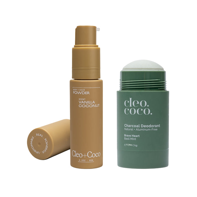 A yellow bottle of Cleo & Coco Hair & Body Powder + free gift is next to a green stick labeled Cleo & Coco Charcoal Extra Strength Deodorant, Natural + Aluminum-Free Brave Heart Basil Mint.