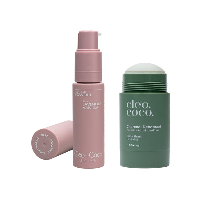 A purple container of Cleo & Coco Hair & Body Powder sits beside a green Charcoal Extra Strength Deodorant tube, labeled Brave Heart Basil Mint. Both talc-free products are by Cleo & Coco.