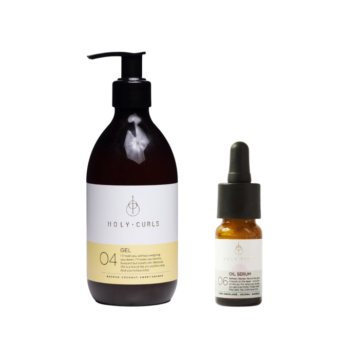 A pump bottle of Holy Curls Gel + free gift, enriched with baobab and coconut oil for defined curls, is placed next to a small dropper bottle of Holy Curls Oil Serum. Both have minimalist white labels with black and gold accents, set against a pristine white background.