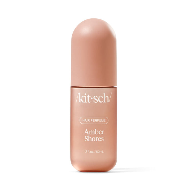 The Hair Perfume by Kitsch, named Amber Shores, features odor-eliminating technology in a sleek, matte rose-colored bottle with white text. It holds 1.7 fl oz (50 ml), perfect for refreshing hair effortlessly.