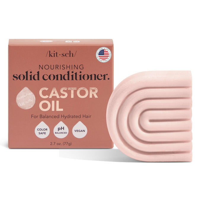 The image features a pink, arch-shaped Castor Oil Nourishing Conditioner Bar by Kitsch beside its packaging. The text reads: nourishing solid conditioner with castor oil, ideal for dry hair and frizz control, color safe, pH balanced, vegan, and made in the USA.