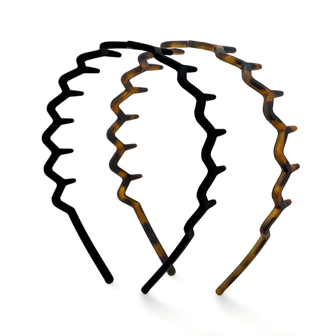 Two Kitsch Zig Zag Headbands are shown on a white background: one in black and the other with a brown tortoiseshell pattern. Made from recycled plastic, they have a wide-toothed design and non-slip grip for security.