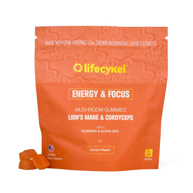 A bright orange resealable bag of Lifecykel AM Gummies - Focus & Energy, with lion’s mane, cordyceps, guarana, and alpha-GPC for natural energy and focus. Lemon peach flavor. Two gummies in front of the 60-count pack.
