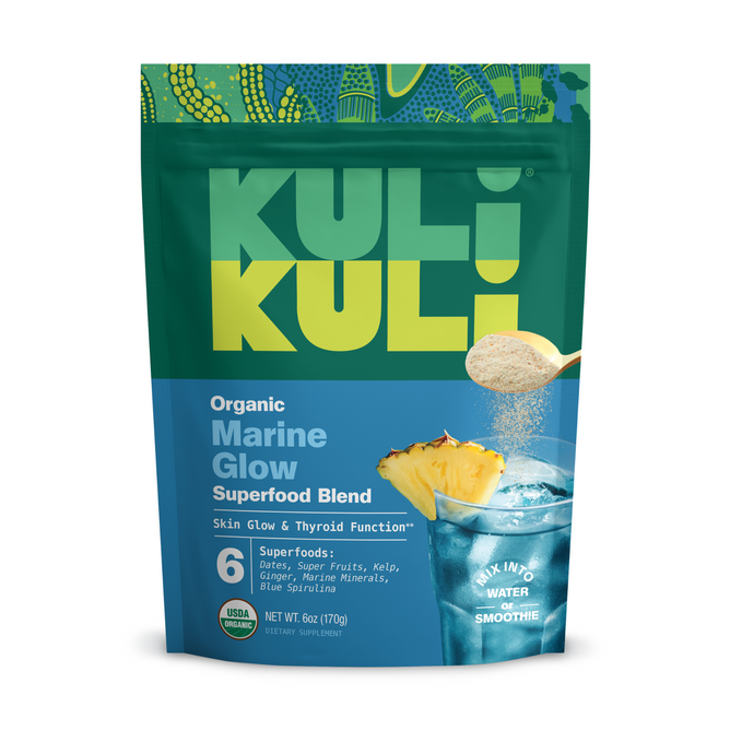 A pouch of Kuli Kuli Foods Marine Glow Organic Luminizing Blend, with green and blue branding, pineapple imagery, and a spoonful of powder. The packaging highlights sustainably harvested seaweeds and tropical fruits for skin and thyroid benefits.