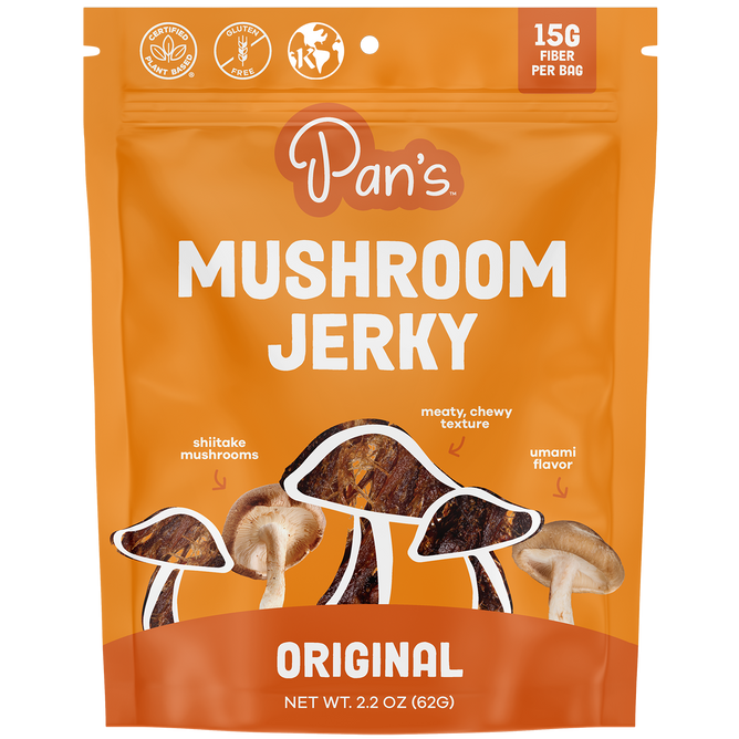 Pans Original Mushroom Jerky features a vibrant orange package displaying shiitake mushrooms and jerky strips. It boasts 15G Fiber Per Bag, a meaty, chewy texture, and rich umami flavor, along with gluten-free and vegan icons for conscious snacking.