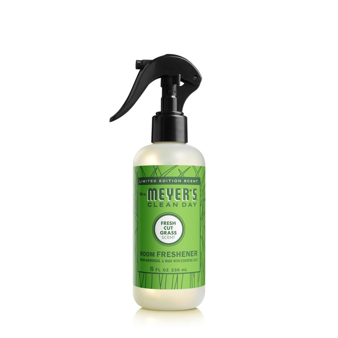 A limited edition Mrs. Meyers Room Freshener in an 8 fl oz spray bottle with a black nozzle boasts a green label, Fresh Cut Grass scent, and essential oils.