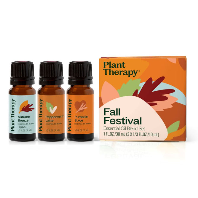 Three brown bottles of essential oils labeled Autumn Breeze Essential Oil, Peppermint Latte Essential Oil, and Pumpkin Spice are next to a colorful box titled Plant Therapy Fall Festival Essential Oil Blend Set.