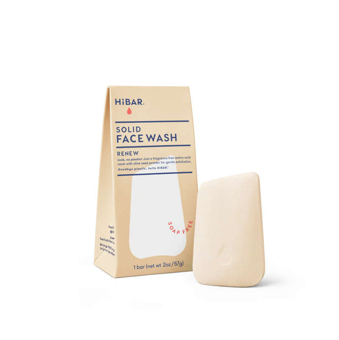 The beige package labeled HiBAR Renew Solid Face Wash showcases product details and its soap-free formula. The adjacent angled wash bar offers gentle exfoliation, using nourishing olive seed powder for a refreshing cleanse.