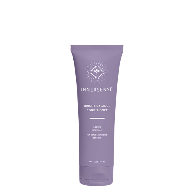 The Innersense Organic Beauty Bright Balance Conditioner - Travel Size has a purple tube with the brand logo and text, “A violet toning conditioner to neutralize brass and “Lift-après-shampooing tonifiant. This 2 fl. oz. (59 mL) container features a silicone-free formula for balanced care.