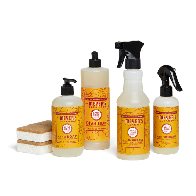 The fall-bakers-bundle from Grove Collaborative features Mrs. Meyers Clean Day products in apple cider scent—hand soap, dish soap, multi-surface cleaner, and room freshener—arranged with two sponges on a white background.
