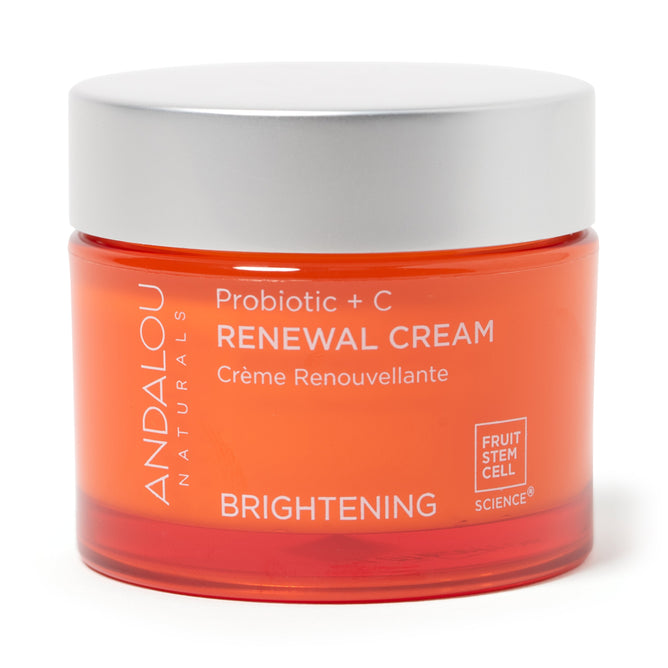 An orange jar with a grey lid is labeled Brightening Probiotic + C Renewal Cream by Andalou Naturals. The text features Brightening and Fruit Stem Cell Science in white, highlighting vitamin Cs power.