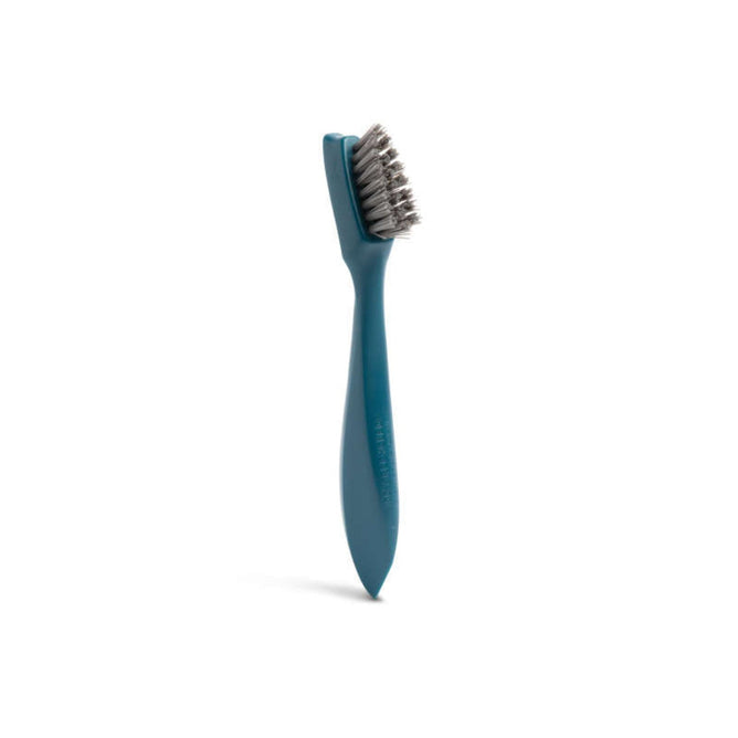 The Full Circle Grout Brush, made from recycled ocean plastic, features a green handle and tough bristles, standing upright on a white background.