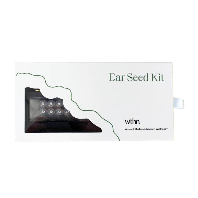The image shows a white box labeled Acupressure Crystal Ear Seed Kit with ear seeds in a small cutout. Green decorative lines accentuate the design, showcasing the brand WTHN and the tagline Ancient Medicine, Modern Wellness, emphasizing acupressure and pain relief benefits.