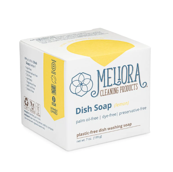 Meliora Dish Soap Bar comes in a white box with zero-waste, plastic-free packaging and offers a refreshing lemon scent. Its palm oil-free, dye-free, preservative-free, and showcases a women-owned logo for an eco-friendly cleaning solution.