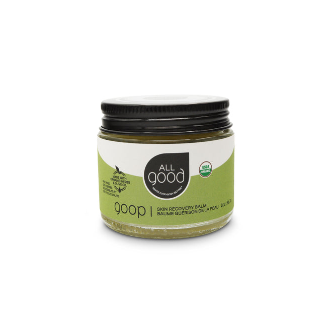 A small jar of Goop by All Good has a green label and a black screw-on lid. This USDA-certified organic moisturizing salve is excellent for skin healing and care.