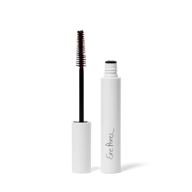 An Ere Perez white tube of Avocado Waterproof Mascara displays the brand name in cursive. Against a plain background, the open tube shows a black brush with brown product. This vegan mascara, infused with nourishing oils, ensures long-lasting wear.