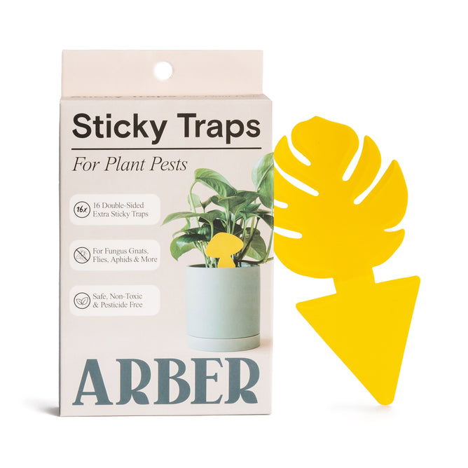 The image displays a box of Arbers Sticky Traps to Trap Indoor and Greenhouse Pests, featuring 16 double-sided yellow monstera leaf-shaped traps. These chemical-free traps target fungus gnats, flies, aphids, and more for safe, non-toxic pest control.