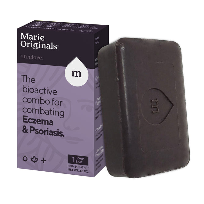 A purple and black Marie Originals box sits beside a rectangular black bar labeled as Eczema/Psoriasis Relief Soap, promoting its use for alleviating eczema and psoriasis with natural, homeopathic bioactive ingredients.