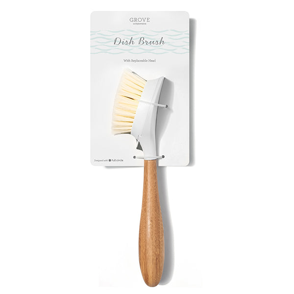 A Grove Co. dish brush with a bamboo handle and white bristles is attached to its packaging, which highlights the Replaceable Head Bristle Dish Brushs convenient feature.