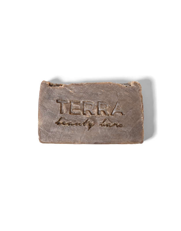 The Clean Green Tea Tree Facial Beauty Bar by Terra Beauty Bars, rectangular and brown, is infused with matcha tea and green sea clay, elegantly engraved with the brand name against a plain white background.
