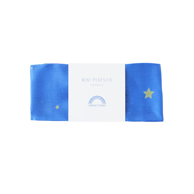 A blue playsilk with gold stars, wrapped in a white label, reads Mini Playsilk for Open-Ended, Imaginative Play with Sarahs Silks rainbow logo. Inspired by Montessori and Waldorf principles, it’s ideal for creative play.
