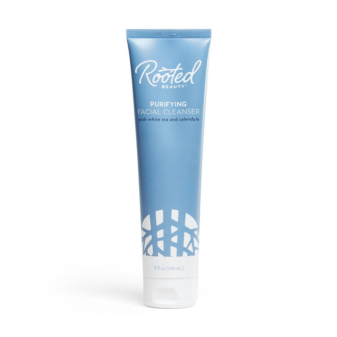 A 5 fl oz blue tube of Rooted Beautys Purifying Facial Cleanser with white tea and calendula features white text and an abstract design. Made from plant-based ingredients, this detoxifying cleanser is EWG VERIFIED™.