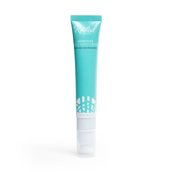 The Rooted Beauty Sensitive Skin Daily Moisturizer comes in a turquoise tube with a white cap, featuring aloe and chamomile for delicate skin. It has a leaf pattern at the bottom, is non-greasy, and proudly EWG VERIFIED™ for peace of mind.