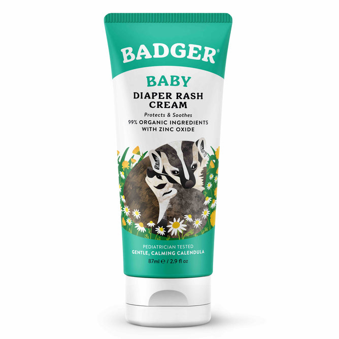 A green tube of Badger Balm Diaper Cream features a badger among daisies, highlighting 99% organic ingredients with non-nano zinc oxide and soothing organic calendula, all pediatrician tested. The tube contains 2.9 fl oz.
