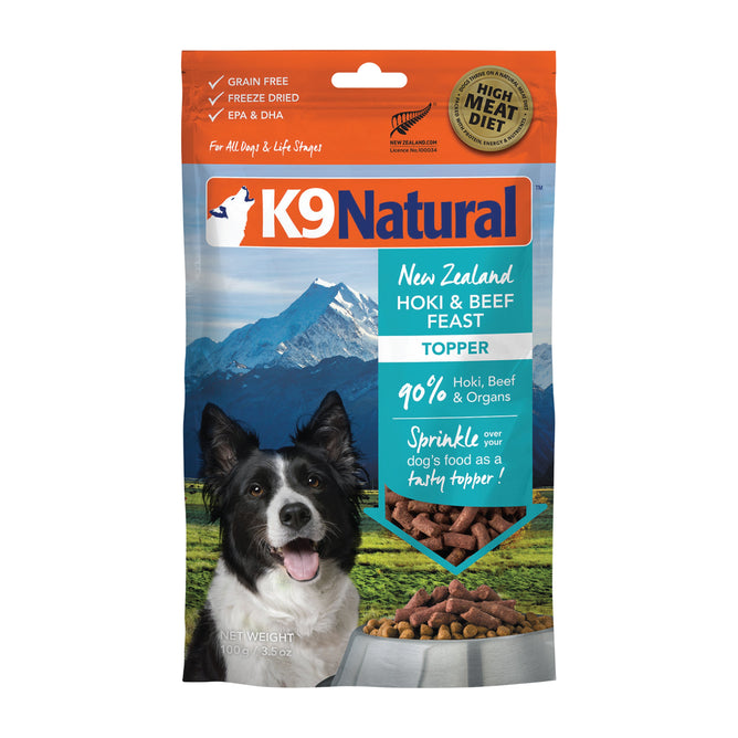 The K9 Natural Grain-Free Freeze-Dried Dog Food Topper features natural flavors and showcases a dog in front of majestic mountains and a clear blue sky, highlighting its premium New Zealand ingredients.