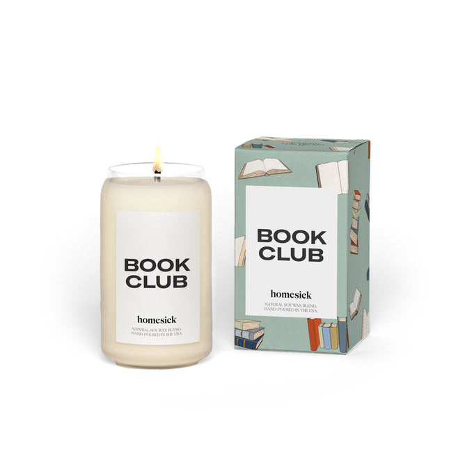 The Book Club candle by Homesick, made with natural soy wax, sits in a glass jar with its box adorned with book illustrations and labeled Book Club and homesick. This cruelty-free candles white wax is presented against a plain white background.