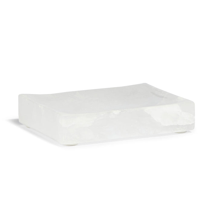 The Peach Stone Soap Dish is a rectangular translucent white dish with a smooth, slightly curved surface. It mimics a marble soap dish with its minimalistic design and stands elegantly on small round feet for enhanced practicality.