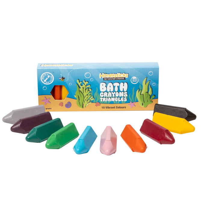 A box of Honeysticks Bath Crayon Triangles, uniquely shaped and rich in color, spills from the package. The packaging features colorful designs and emphasizes its eco-friendly qualities.