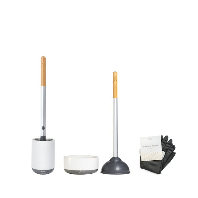 The Grove Co. Toilet Cleaning Starter Set features a stylish white holder and brush, a wooden-handled plunger with a sturdy base, and a matching bowl. It includes black cleaning gloves in packaging, blending modern design with functionality.