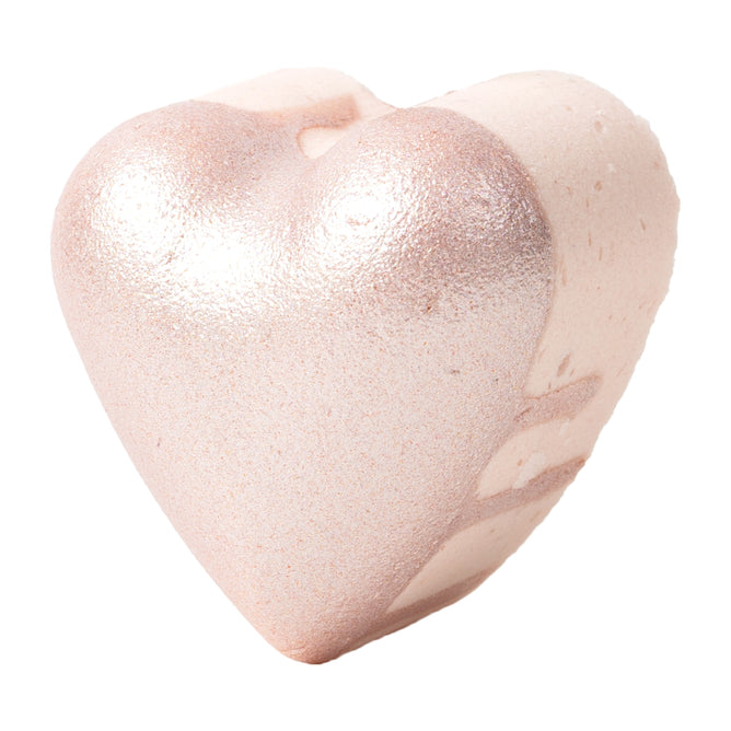 The Jasmine Gardenia Froth Bomb by Pacha Soap Co. is a heart-shaped bath bomb with a metallic rose gold texture and jasmine infusion. Its smooth, subtly speckled surface offers a luxurious spa-like experience against a plain white background.