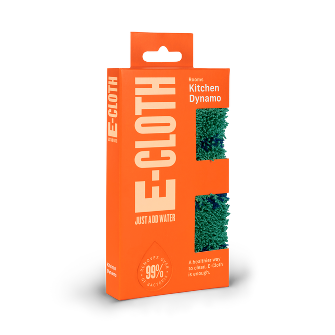 The E-Cloth Kitchen Dynamo Microfiber Scrubber is packaged in bright orange with a green scrubber visible through cutouts. It eco-consciously cleans by removing 99% of bacteria using only water for a healthier clean.