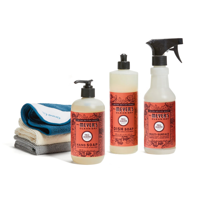 The Mrs. Meyers fall-cleaning-set-mmcd features hand soap, dish soap, and multi-surface spray with three stacked cleaning cloths in white, blue, and gray on a white background.
