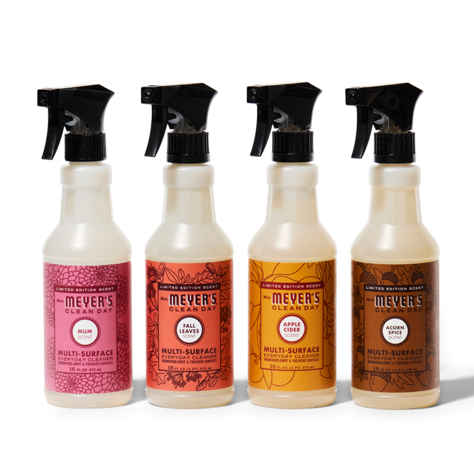 Four Mrs. Meyers Fall Multi-Surface Cleaner Collection bottles are lined up, each flaunting autumn colors and a unique Fall Seasonal scent—Mum, Fall Leaves, Apple Cider, and Acorn Spice.