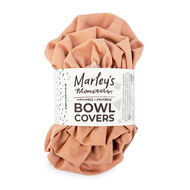 A crumpled, peach-colored reusable fabric from Marleys Monsters perfectly embodies eco-friendly solutions. The Linen Bowl Cover Bundle - Rose is washable and reusable, showcasing a minimalist design with small geometric patterns.